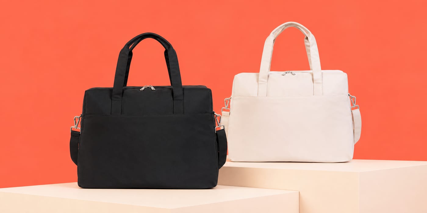 Bolsas Voyage preta e off-white em cenário coral